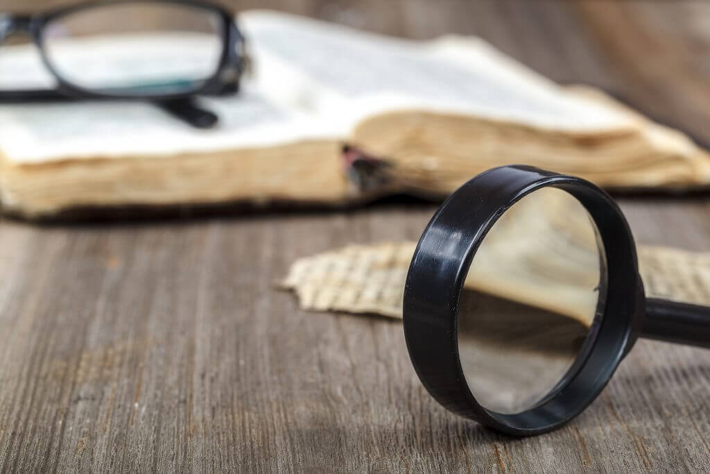Bible, Magnifying Glass, and Piece of Paper